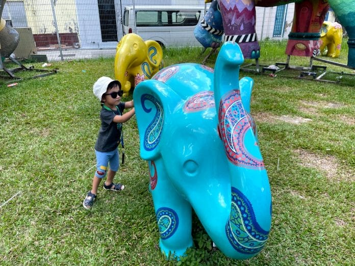 Toddler plays with elephant sculpture